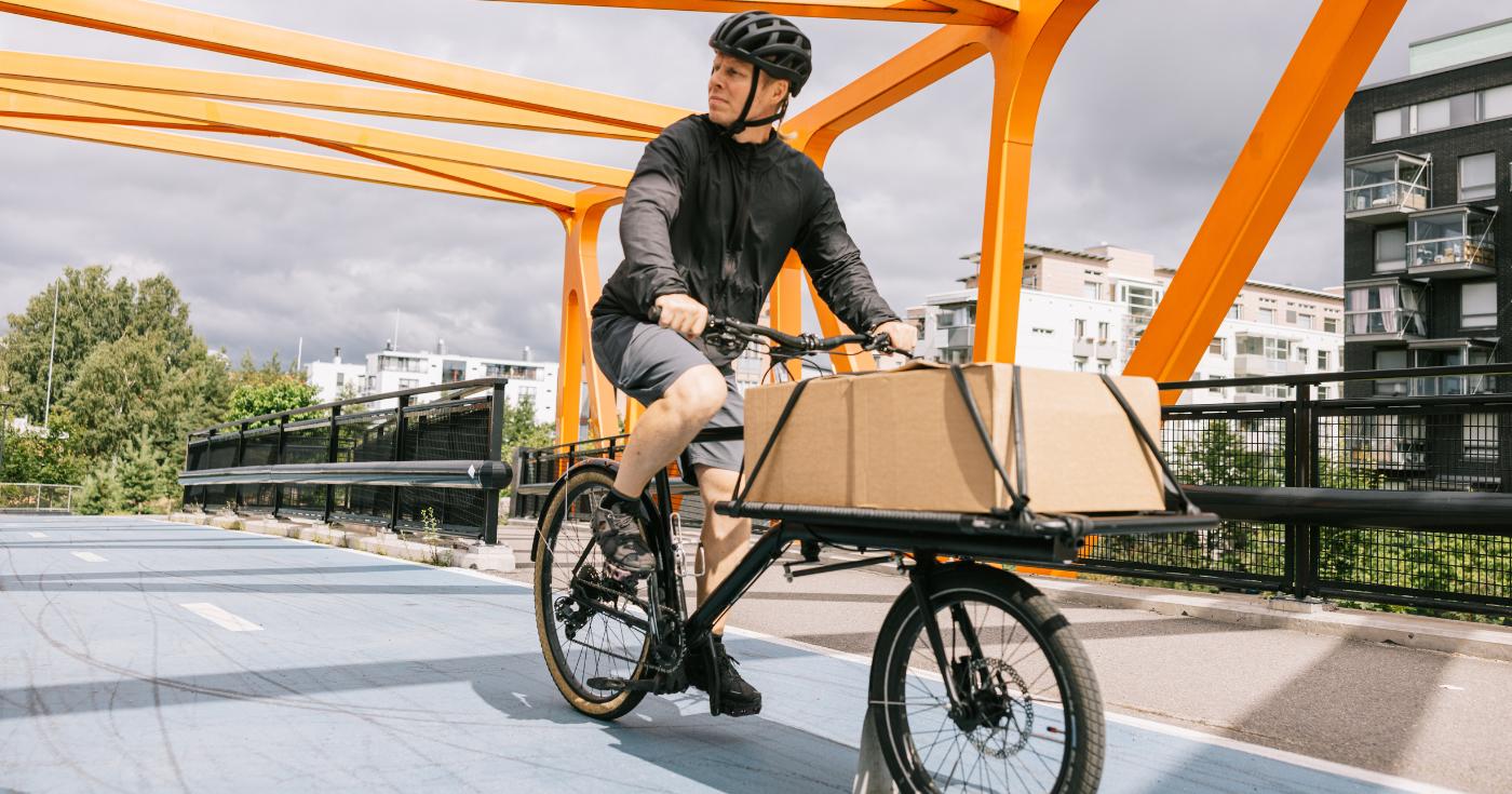 Kurier rozwożący paczki rowerem transportowym